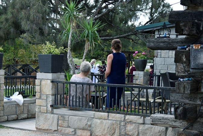 "Family Watches From Deck As Photographer Works With Bride"